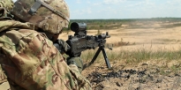 Soldier firing a M240B caliber machine gun 