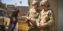 Soldiers talking to a kid